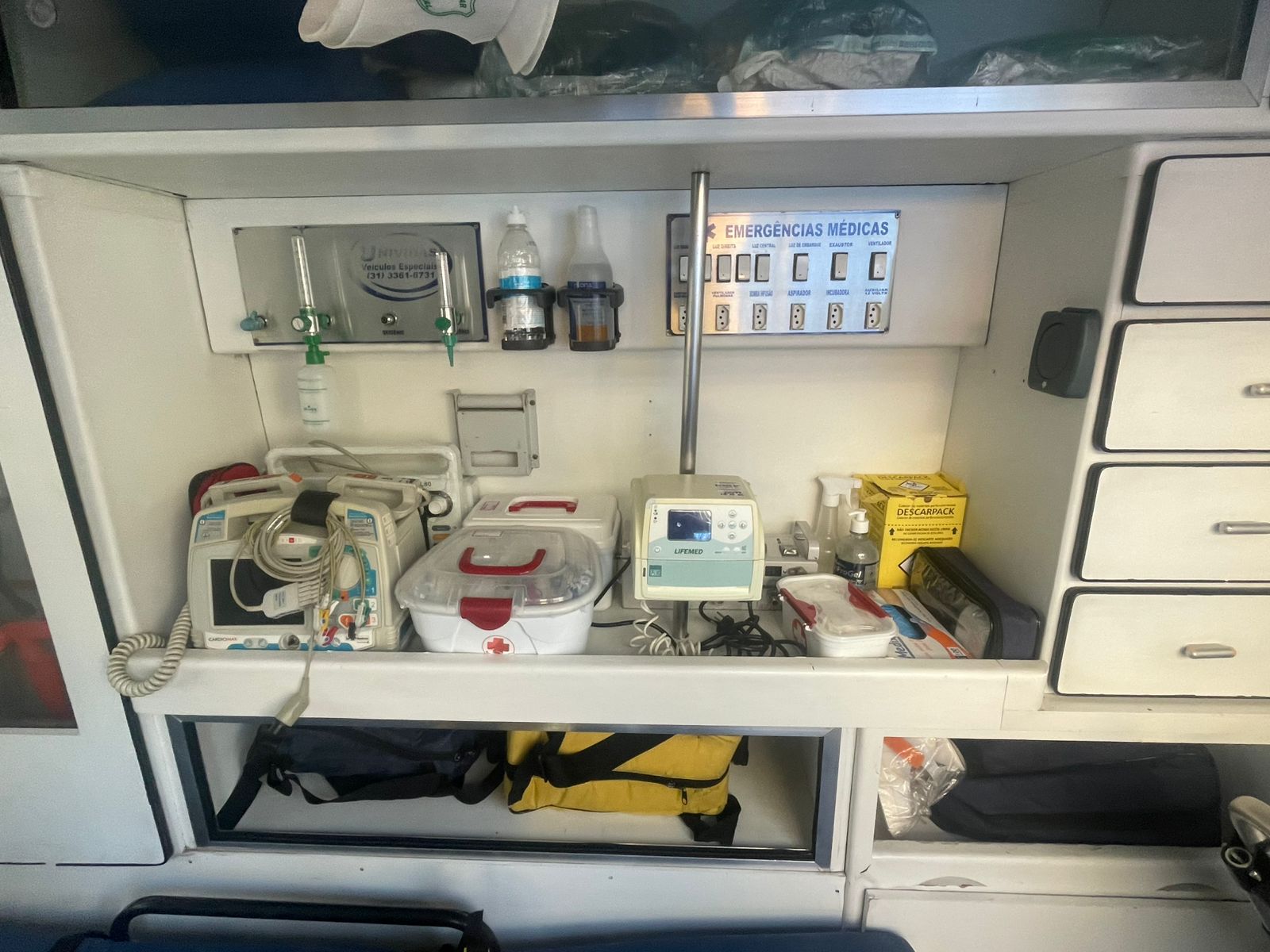 Painel de equipamentos de UTI móvel: monitor desfibrilador, respirador Lifemed e materiais de emergência
