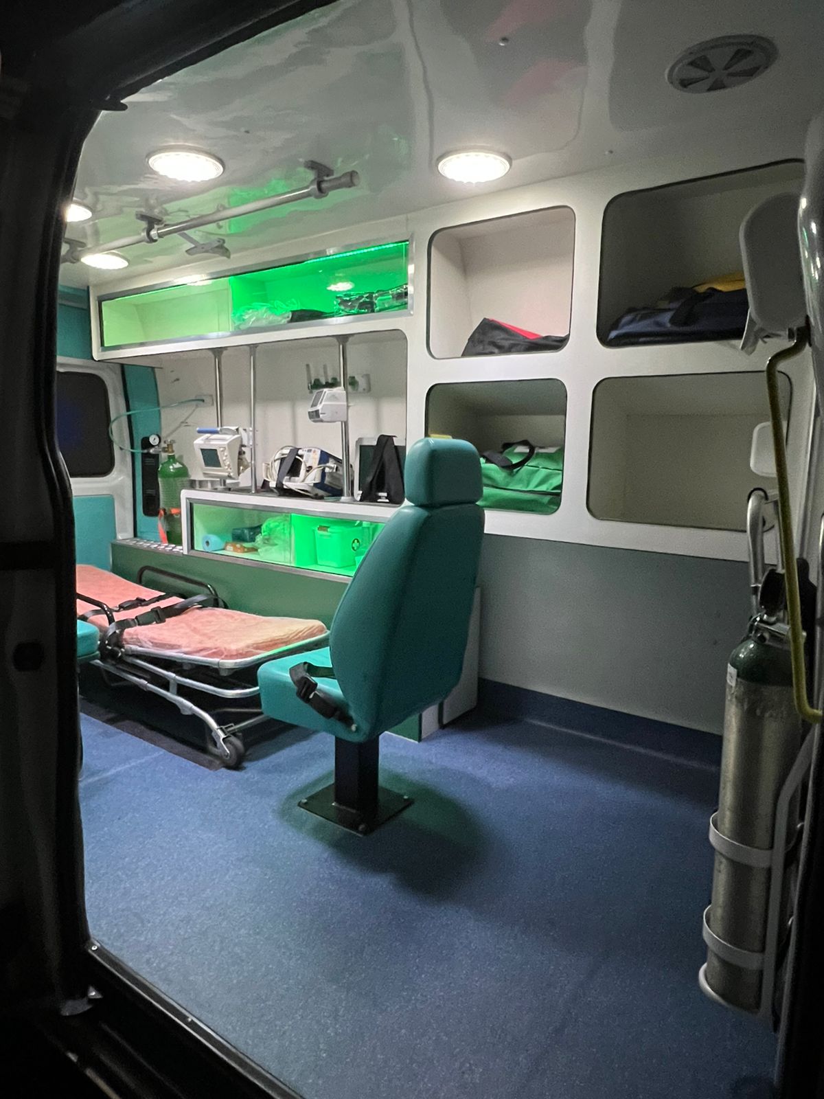 Interior da ambulância UTI com maca, poltrona do socorrista e cilindro de oxigênio